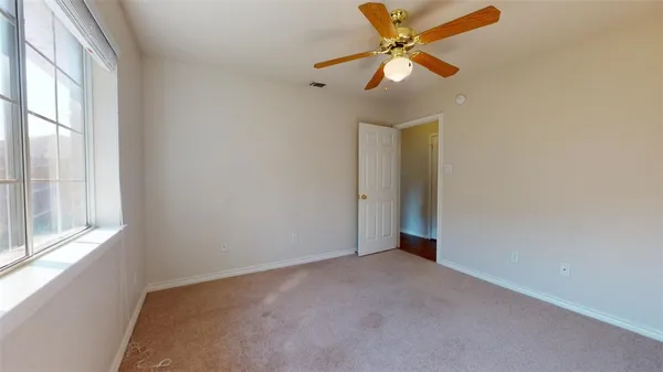 an empty room with fan and windows