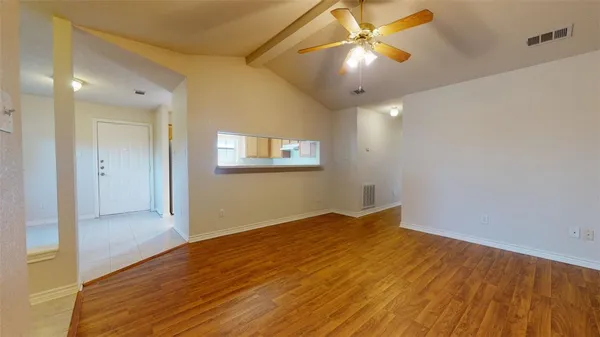 a view of empty room with wooden floor