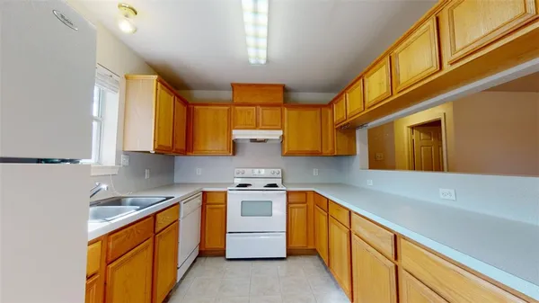 a kitchen with stainless steel appliances granite countertop a sink a stove and a refrigerator