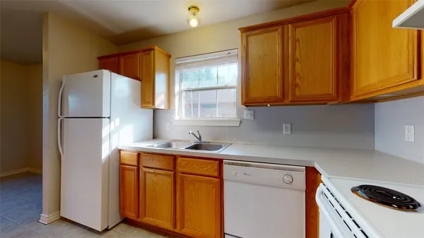 a kitchen with a refrigerator sink and cabinets