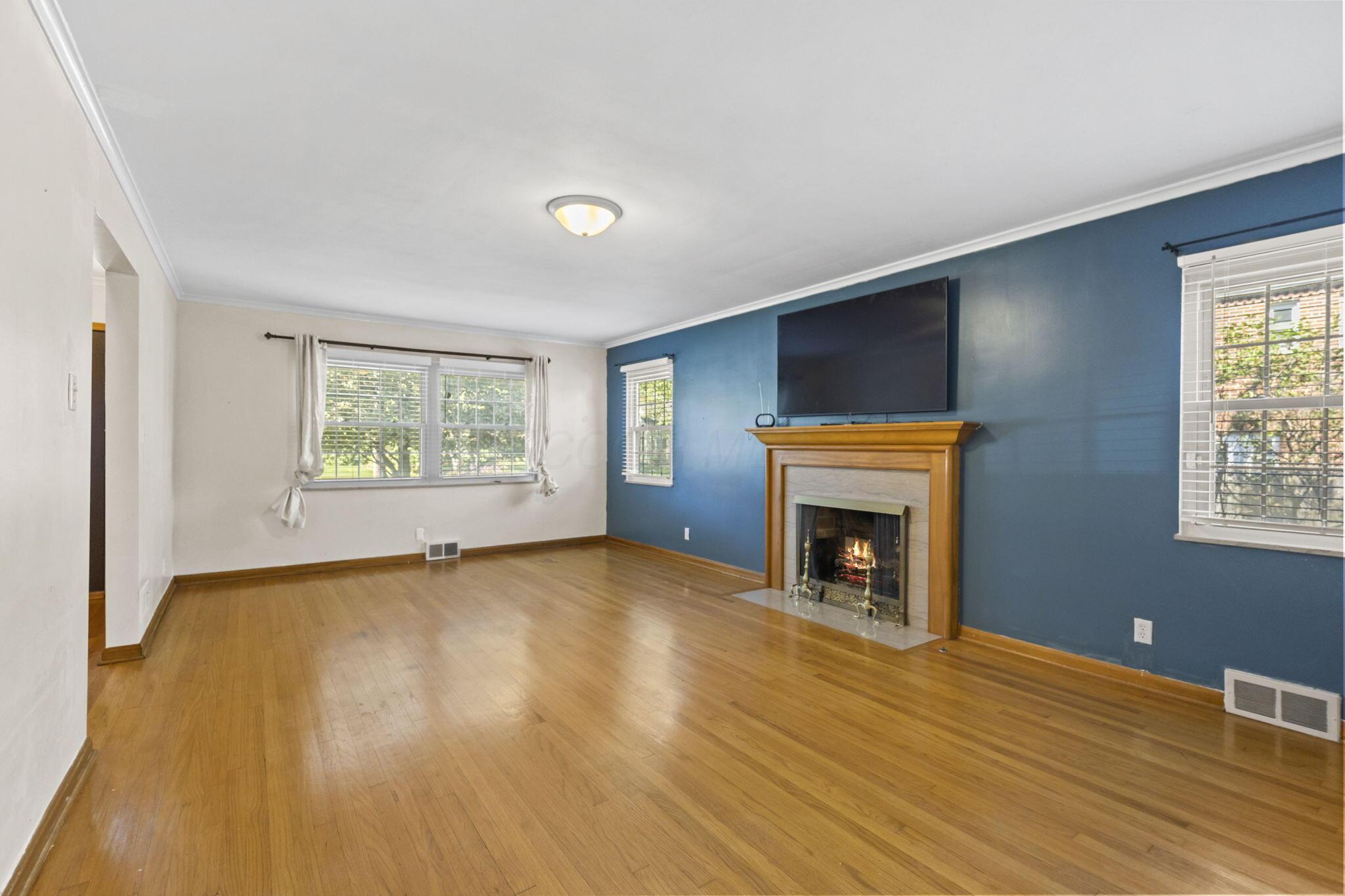 40 South Kellner Road Columbus, OH 43209 - Photo 20 of 57 Hardwood flooring, crown molding, fireplace with mantel, recessed fireplace insert, and multiple windows
