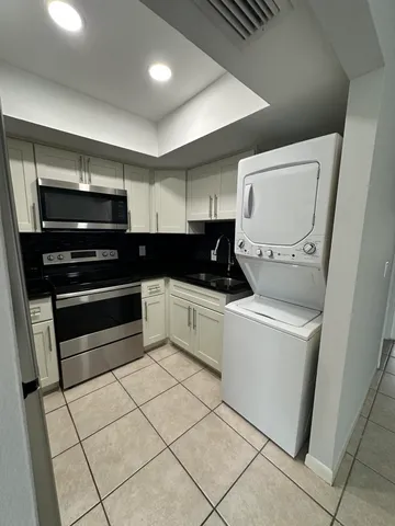 a kitchen with a stove and white cabinets