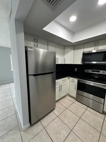 a kitchen with stainless steel appliances granite countertop a refrigerator and a sink