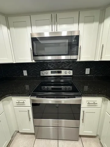 a stove top oven sitting inside of a kitchen