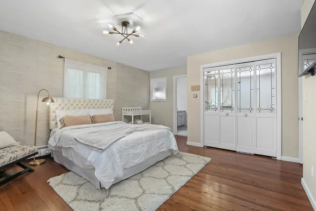 a spacious bedroom with a bed and a chandelier