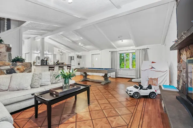 a living room with furniture a table and kitchen view