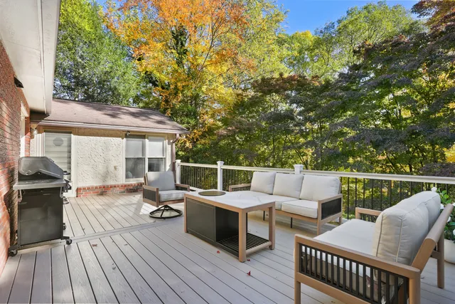 a view of a patio with couches chairs and wooden floor