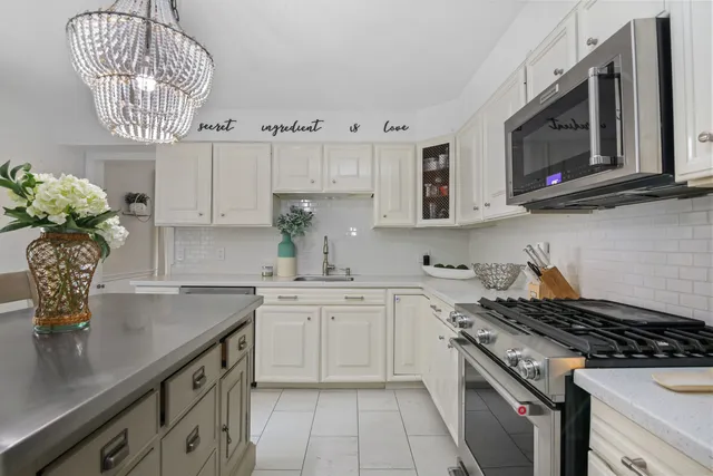 a kitchen with stainless steel appliances granite countertop a sink stove and microwave