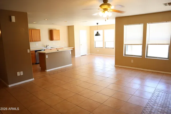 a view of a kitchen with kitchen island granite countertop a sink cabinets and window