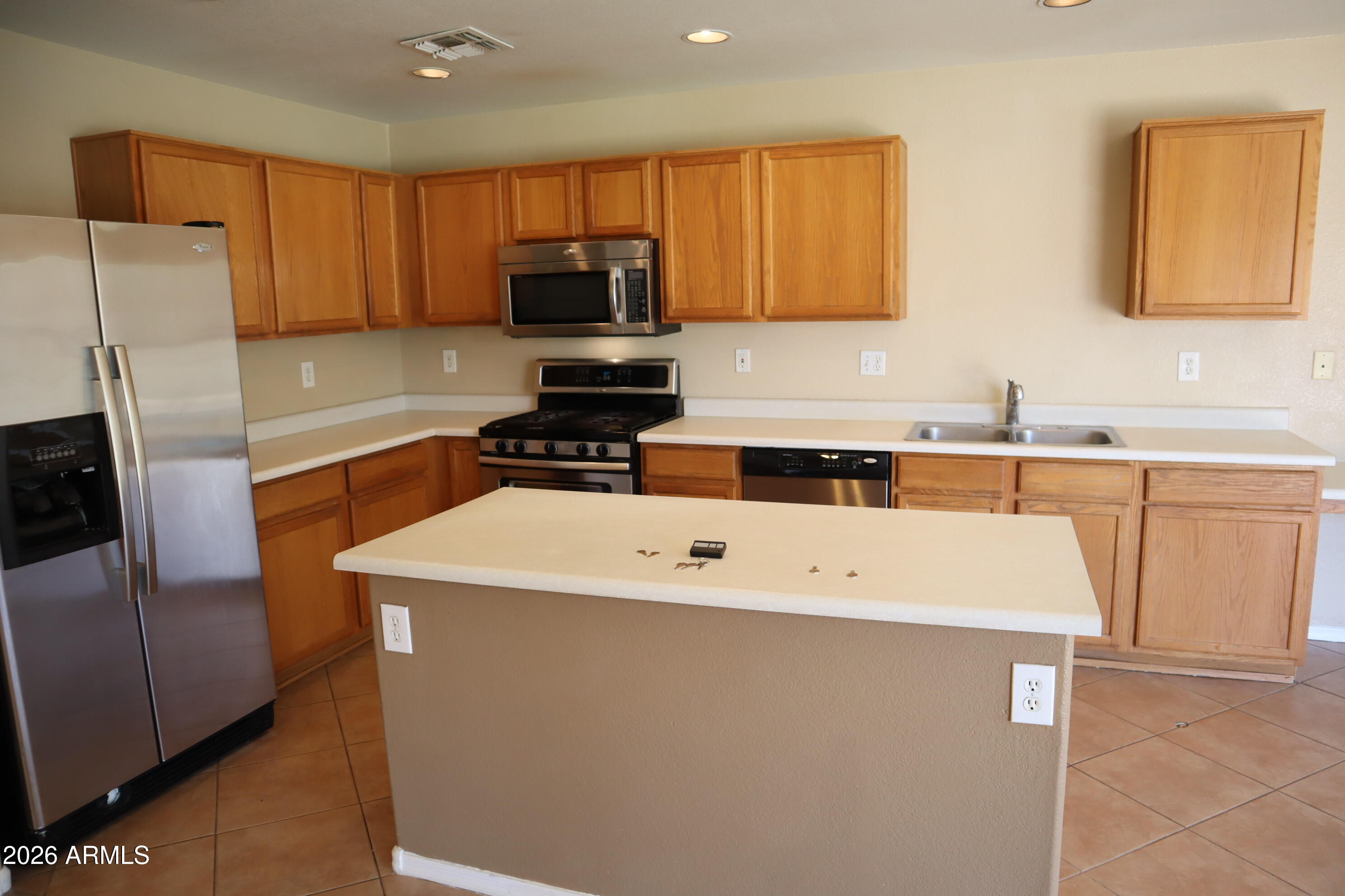 3281 South Martingale Road Gilbert, AZ 85297 - Photo 6 of 15 a kitchen with a sink a stove a microwave and refrigerator