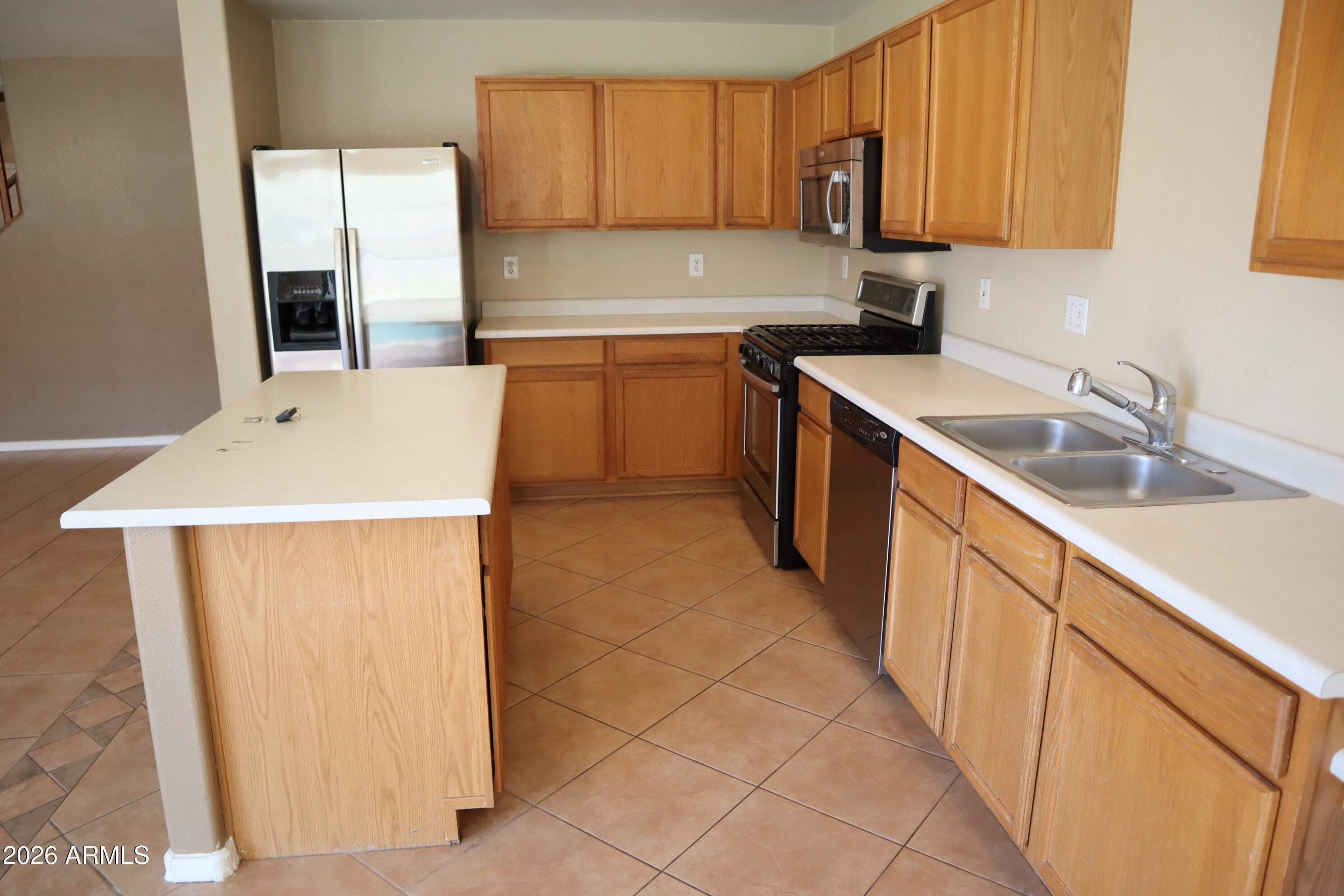 3281 South Martingale Road Gilbert, AZ 85297 - Photo 7 of 15 a kitchen with stainless steel appliances granite countertop a sink stove and refrigerator
