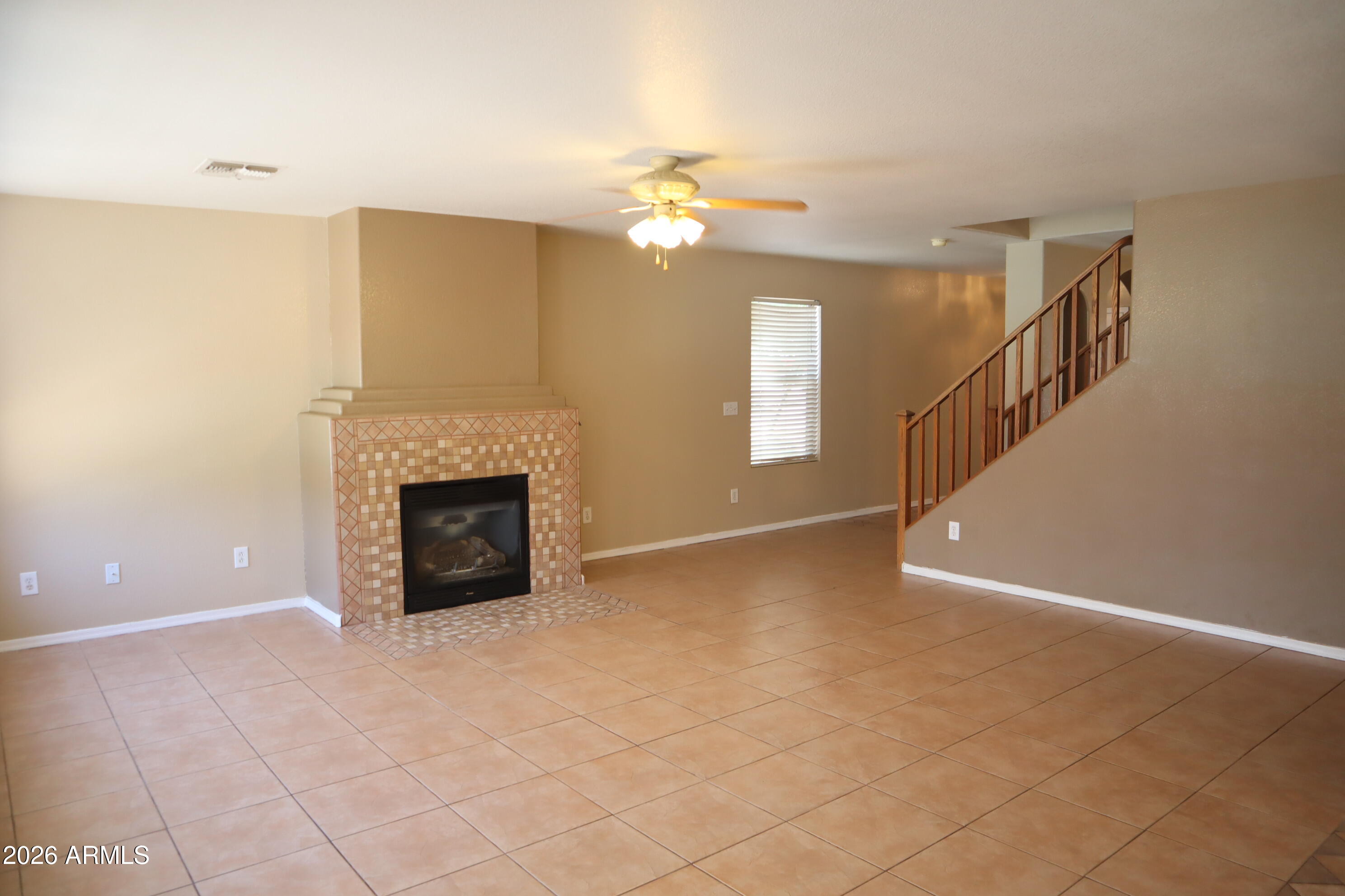 3281 South Martingale Road Gilbert, AZ 85297 - Photo 8 of 15 a view of an empty room with a fireplace and a chandelier fan