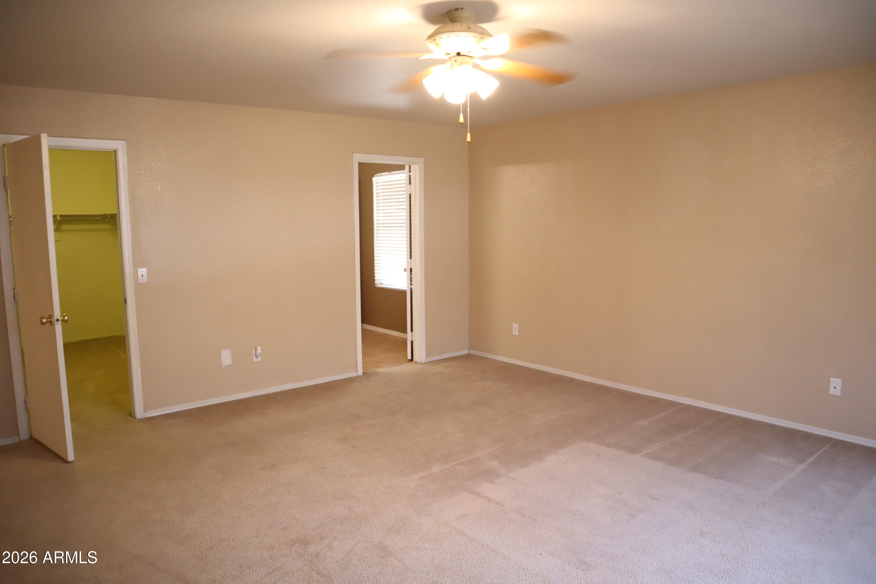 3281 South Martingale Road Gilbert, AZ 85297 - Photo 10 of 15 an empty room with a chandelier fan and windows