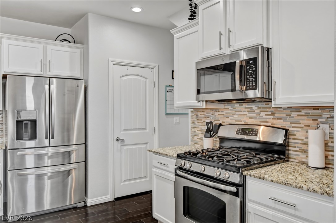 48 Jasmine Point Street Henderson, NV 89074 - Photo 24 of 62 Culinary creativity flows in this well-appointed kitchen, showcasing granite counters and stainless steel appliances.