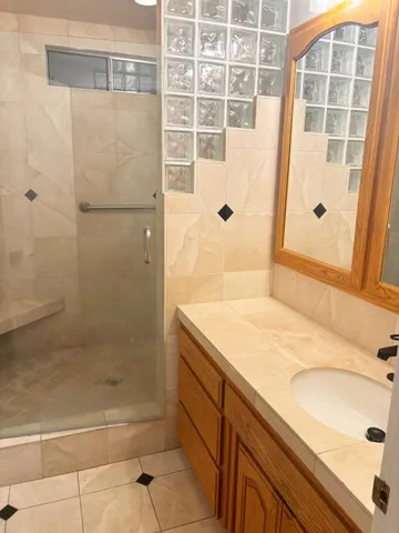 a bathroom with a granite countertop shower and a sink