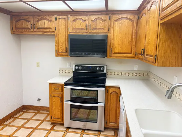 a kitchen with stainless steel appliances a stove a microwave and a sink