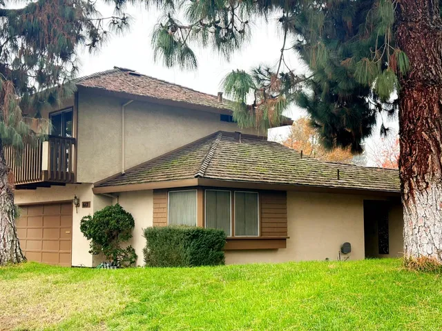 a front view of a house with a yard and palm tree