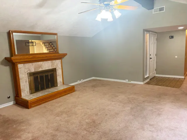an empty room with windows and fireplace