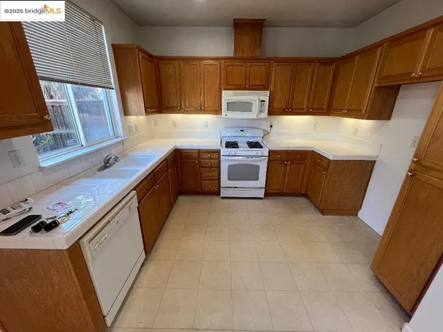 a kitchen with granite countertop a sink stove and refrigerator