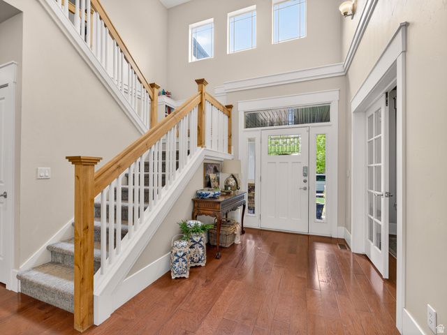 557 Craftsman Way Midway, UT 84049 - Photo 5 of 59 Two-story foyer featuring wood-finish flooring, a grand staircase with carpeted treads, and a white entry door with transom and sidelight windows