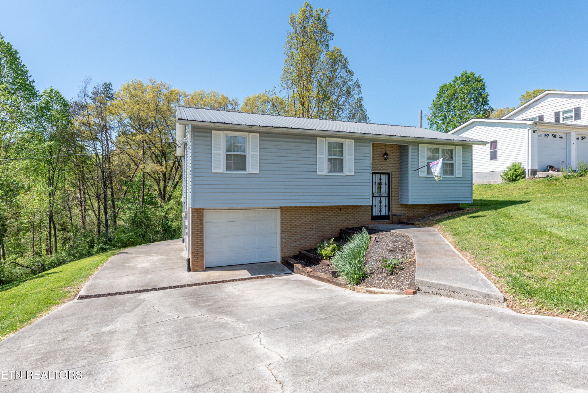 4038 Big Springs Ridge Road Friendsville, TN 37737 - Photo 2 of 26 a front view of a house with a yard and garage