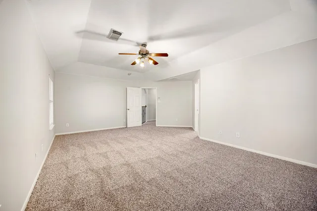 a view of an empty room with a ceiling fan