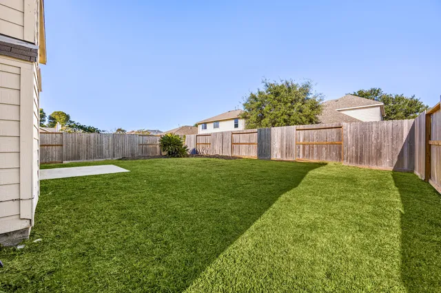 a view of a house with backyard and a tree