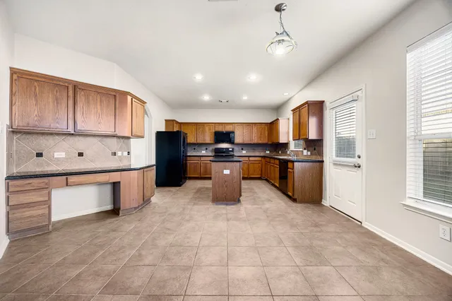 a kitchen with stainless steel appliances granite countertop a refrigerator and a stove top oven