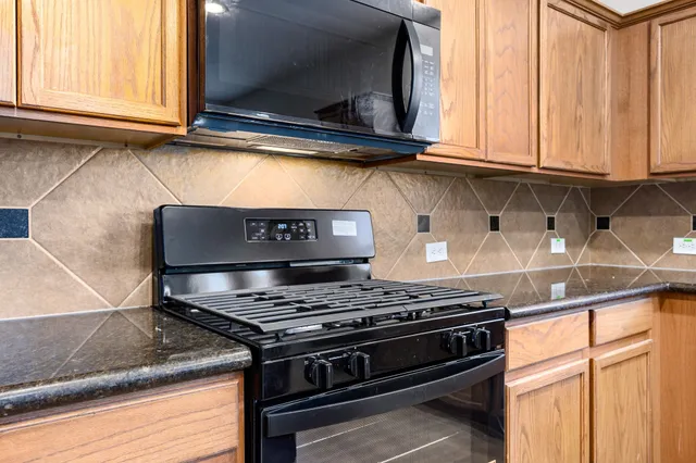 a kitchen with stainless steel appliances granite countertop a stove and a microwave
