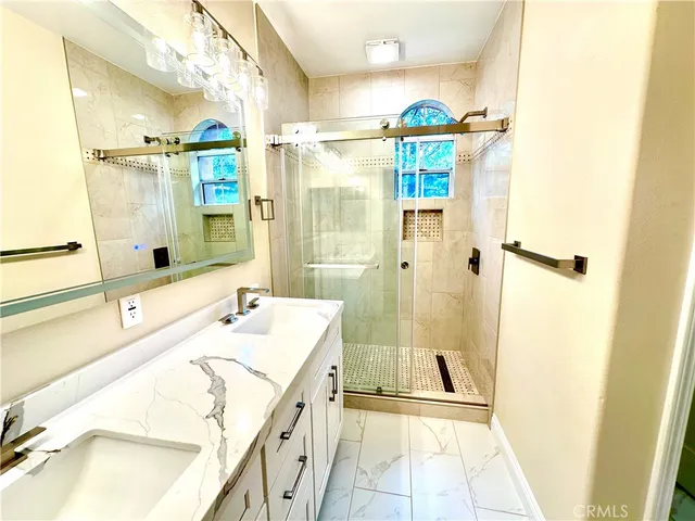 a bathroom with a double vanity sink mirror and bathtub