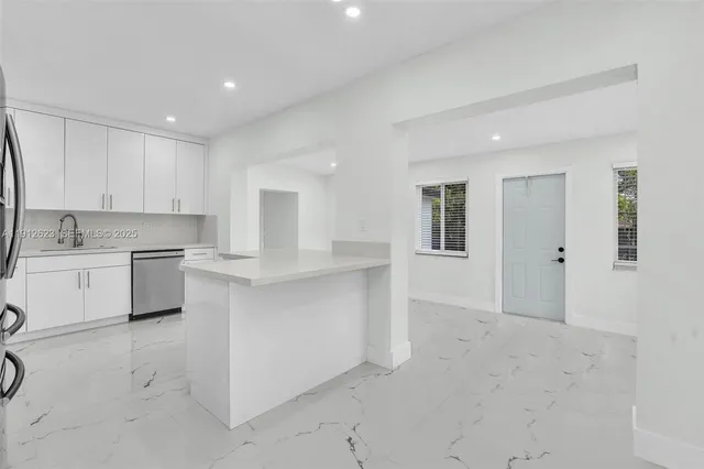 a large white kitchen with white cabinets