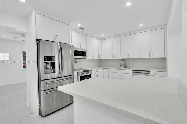 a kitchen with stainless steel appliances a refrigerator sink and microwave