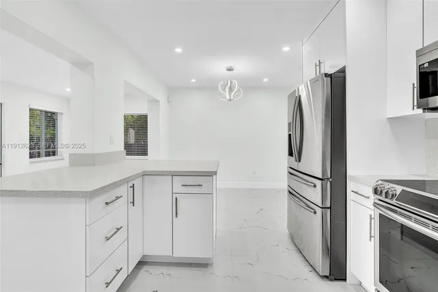 a kitchen with white cabinets and stainless steel appliances