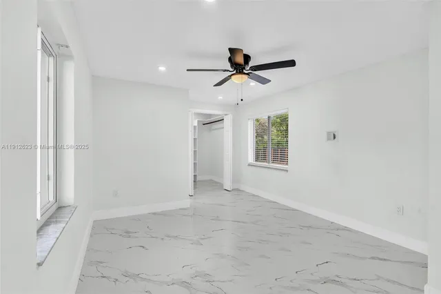 a view of room with ceiling fan and window