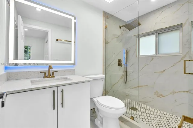 a bathroom with a sink a toilet and shower