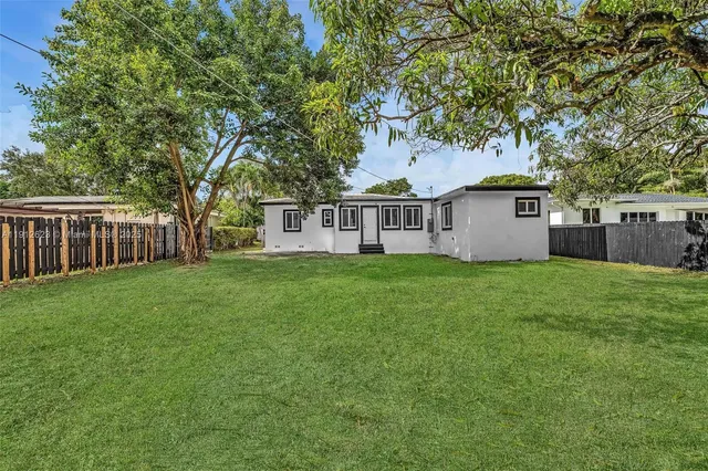 a view of a house with a yard and tree