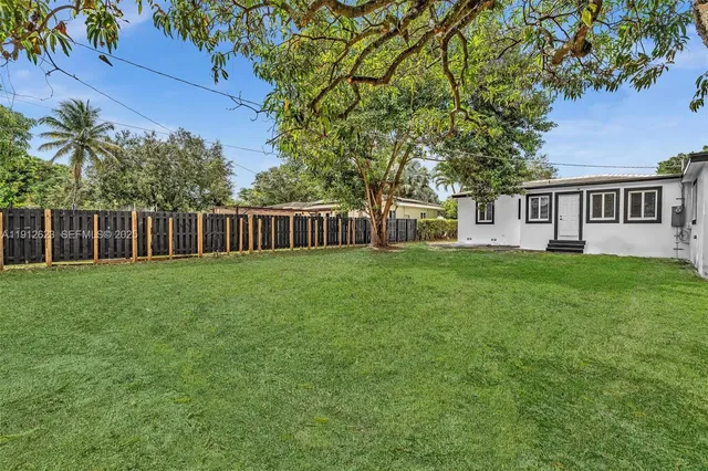 a view of house with backyard and a garden