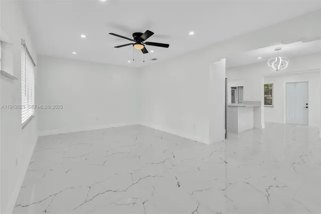 an empty room with a ceiling fan and bathroom