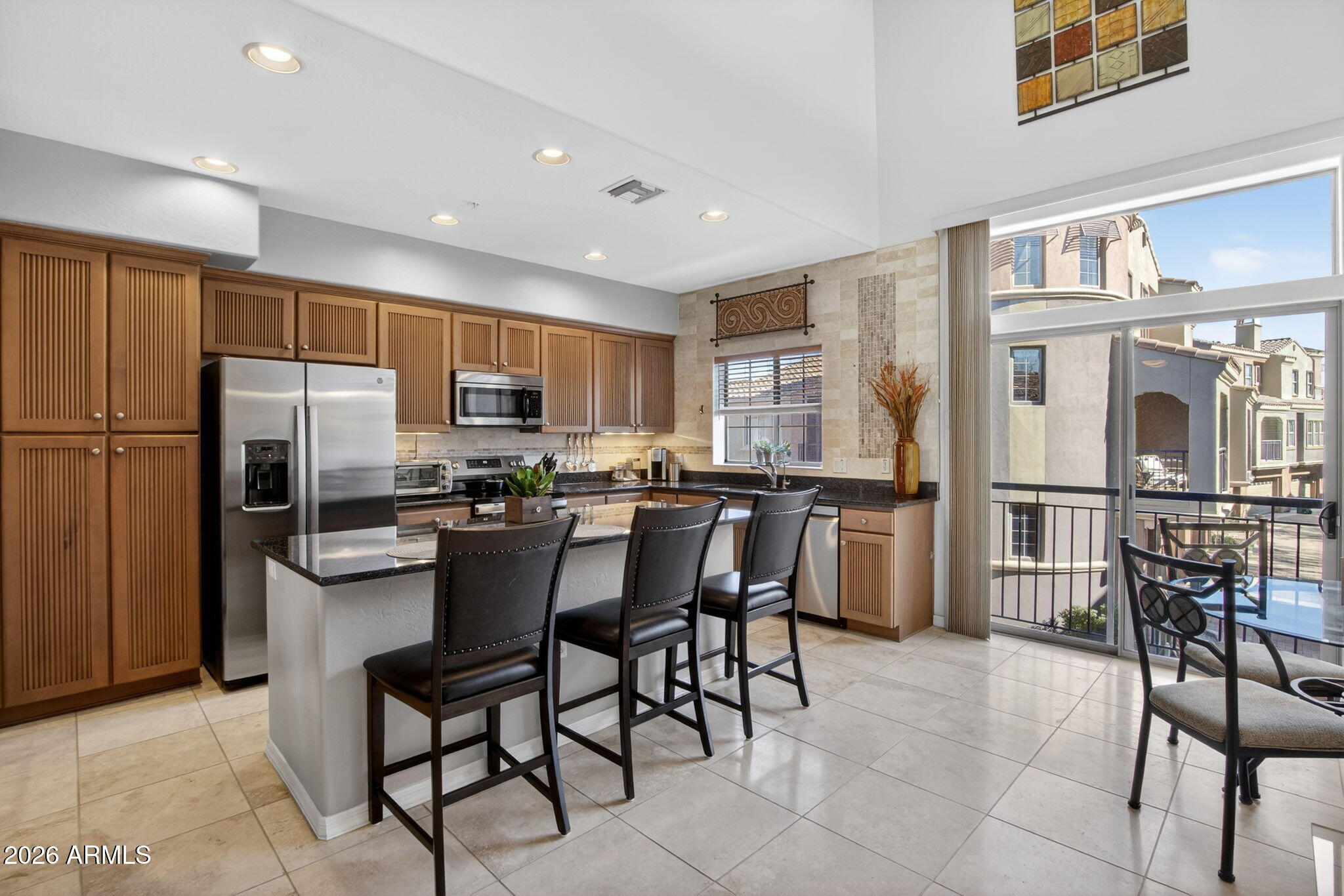 3935 East Rough Rider Road, Unit 1145 Phoenix, AZ 85050 - Photo 3 of 32 a kitchen with stainless steel appliances granite countertop a refrigerator a stove a sink a dining table and chairs