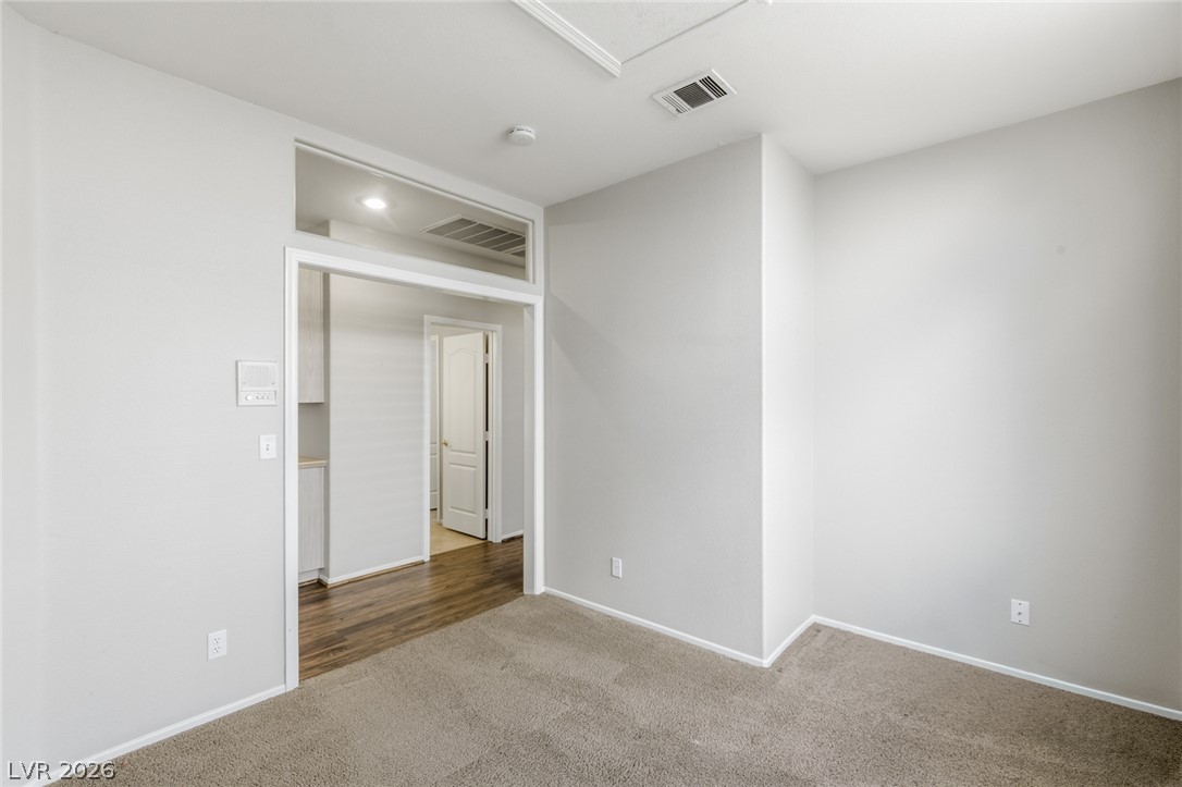 9034 Ridgepointe Way Henderson, NV 89074 - Photo 35 of 56 Soft carpeting meets crisp neutral walls under a high ceiling with a transom window design.