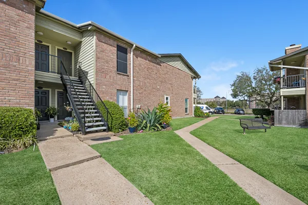 a view of a house with a yard and furniture