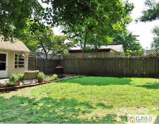 51 Ashley Road Edison, NJ 08817 - Photo 8 of 10 a view of a backyard with table and chairs and wooden fence
