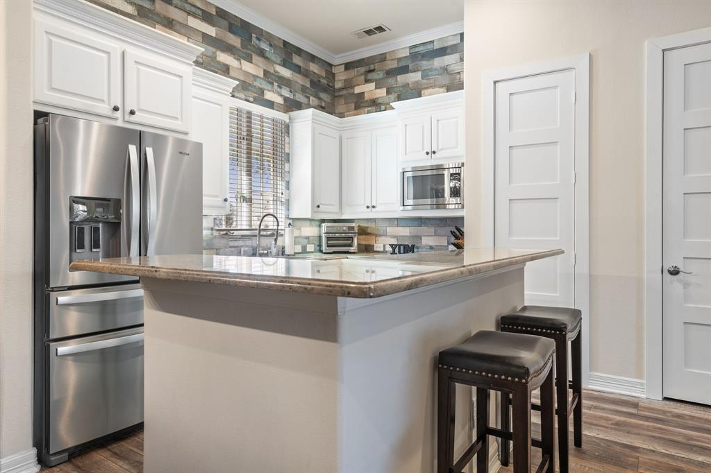8444 Library Street Frisco, TX 75034 - Photo 11 of 36 a kitchen with stainless steel appliances a refrigerator and a stove