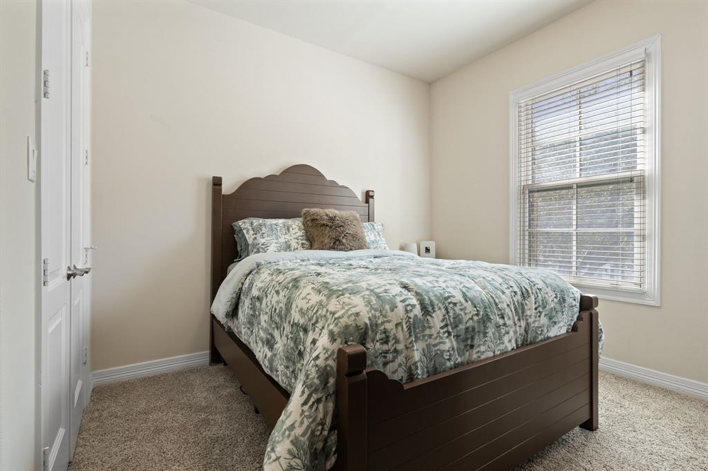 8444 Library Street Frisco, TX 75034 - Photo 22 of 36 a bed sitting in a bedroom next to a window