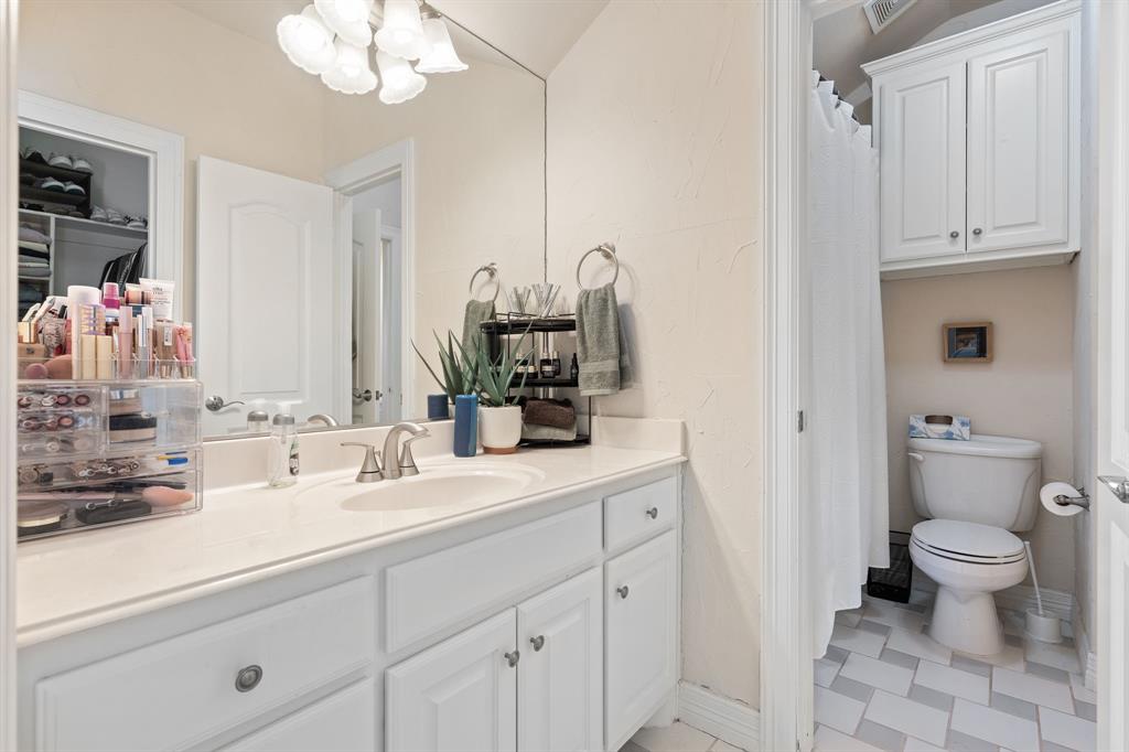 8444 Library Street Frisco, TX 75034 - Photo 29 of 36 a bathroom with a sink a toilet and a mirror