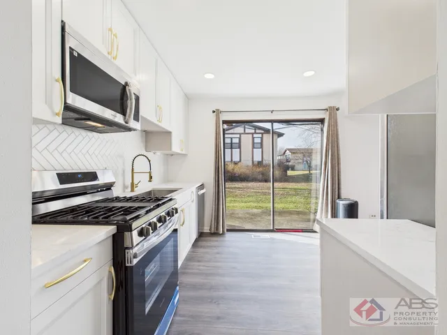 a kitchen with stainless steel appliances a stove a sink and a microwave