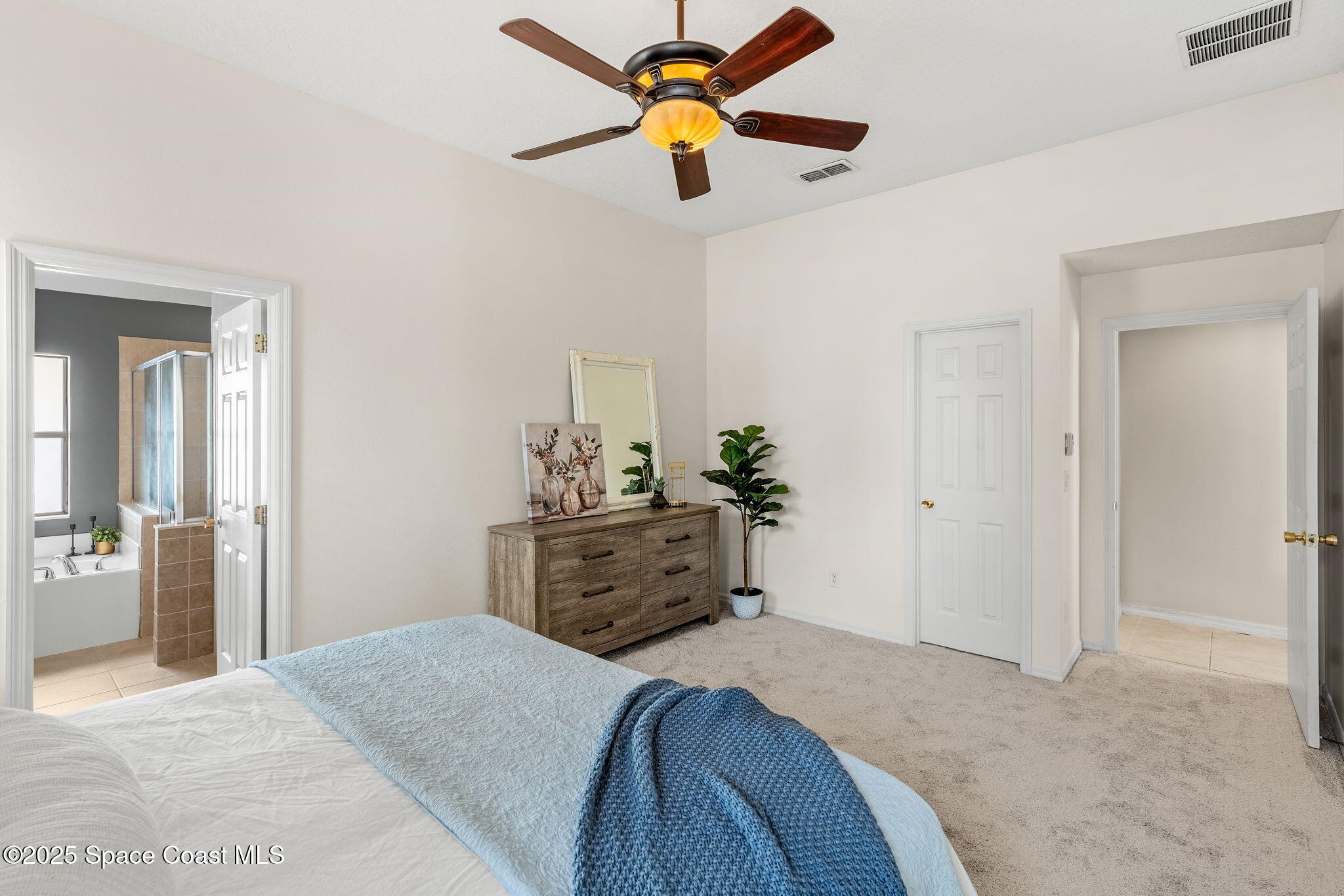 1908 Tullagee Avenue Melbourne, FL 32940 - Photo 22 of 58 a bedroom with a bed and a chandelier fan