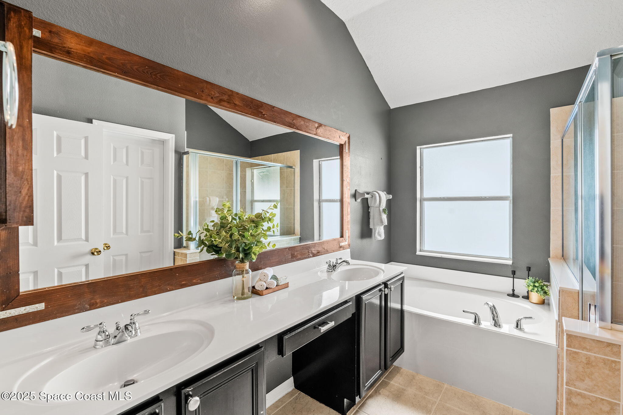 1908 Tullagee Avenue Melbourne, FL 32940 - Photo 23 of 58 a bathroom with a sink double vanity granite tub shower and a mirror