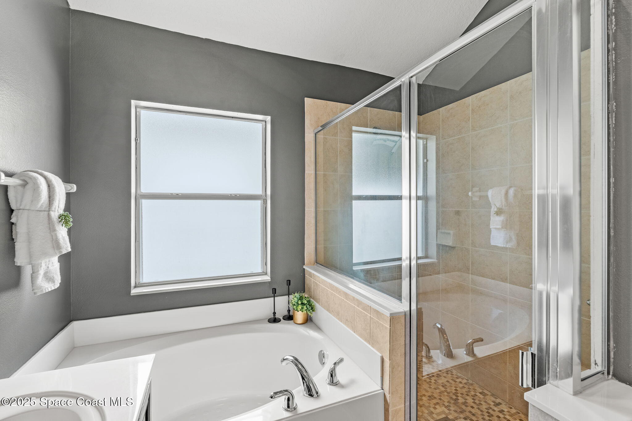 1908 Tullagee Avenue Melbourne, FL 32940 - Photo 24 of 58 a bathroom with a tub and a shower