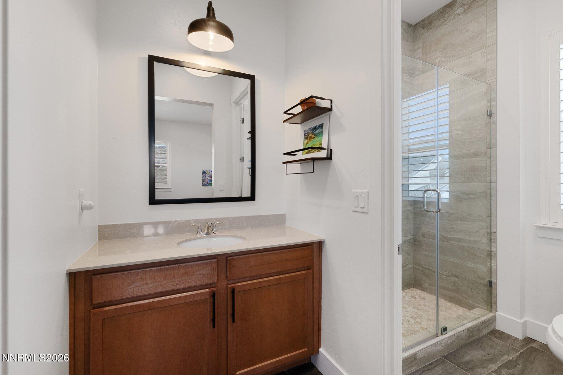 6110 South Pleasant Oak Trail Reno, NV 89511 - Photo 31 of 66 a bathroom with a sink a vanity and a mirror